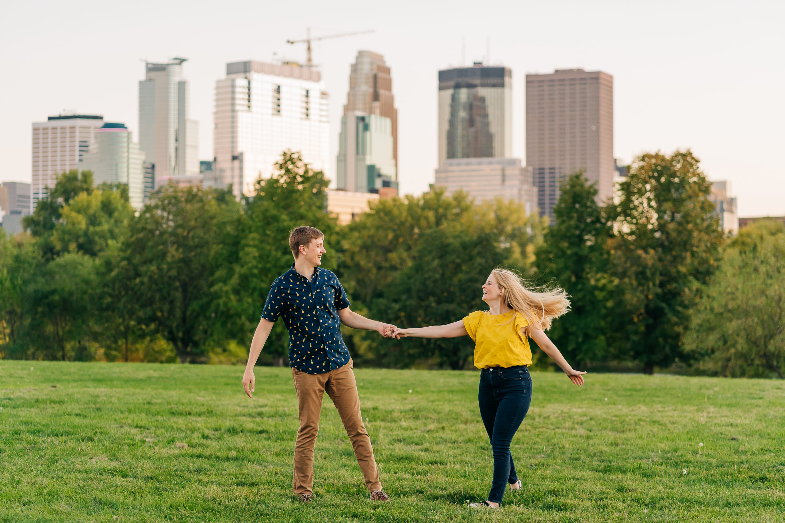 Dancing engagement photo with Minneapolis skyline