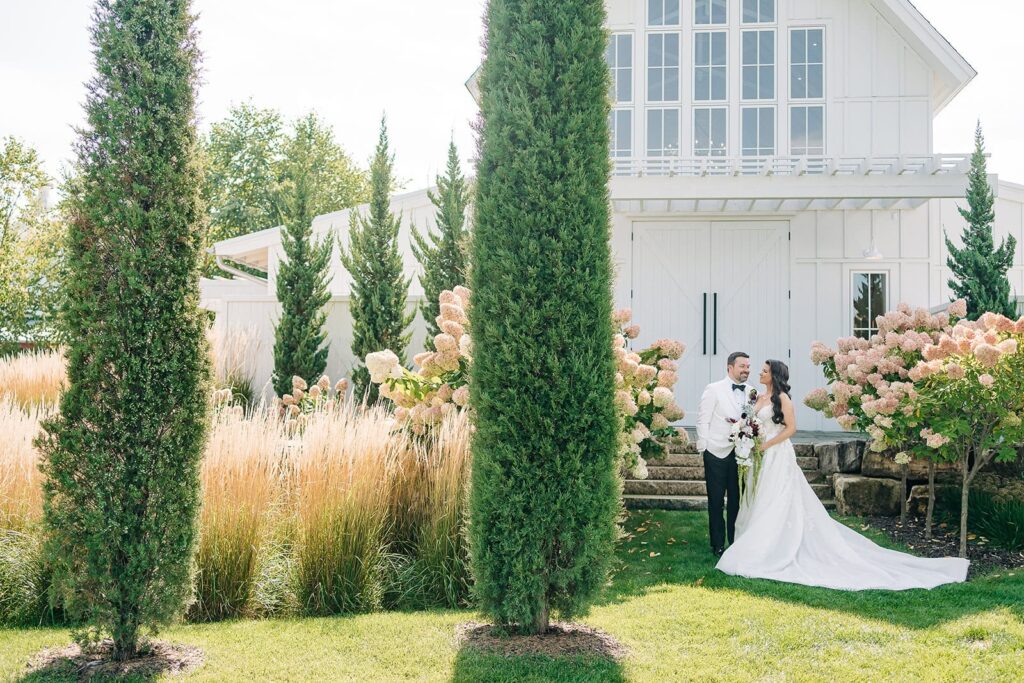 bride and groom infront of redeemed farm on wedding day