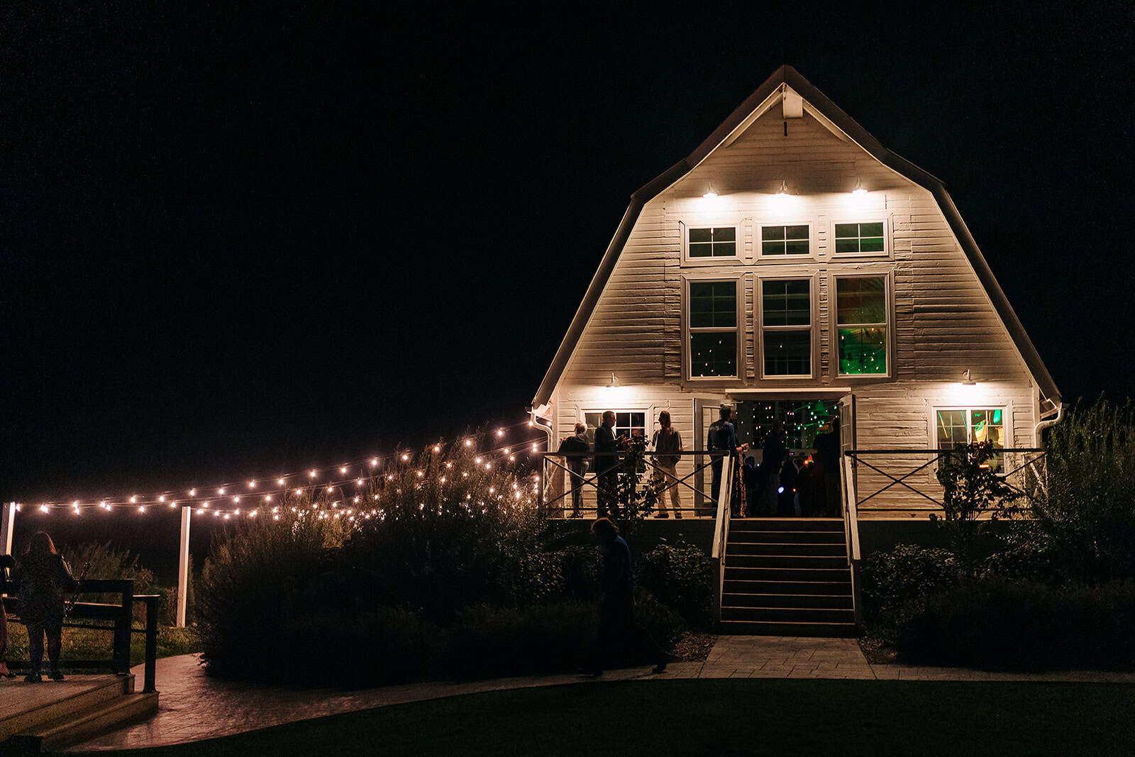 Ivory North venue exterior with modern farmhouse and white barn style at night