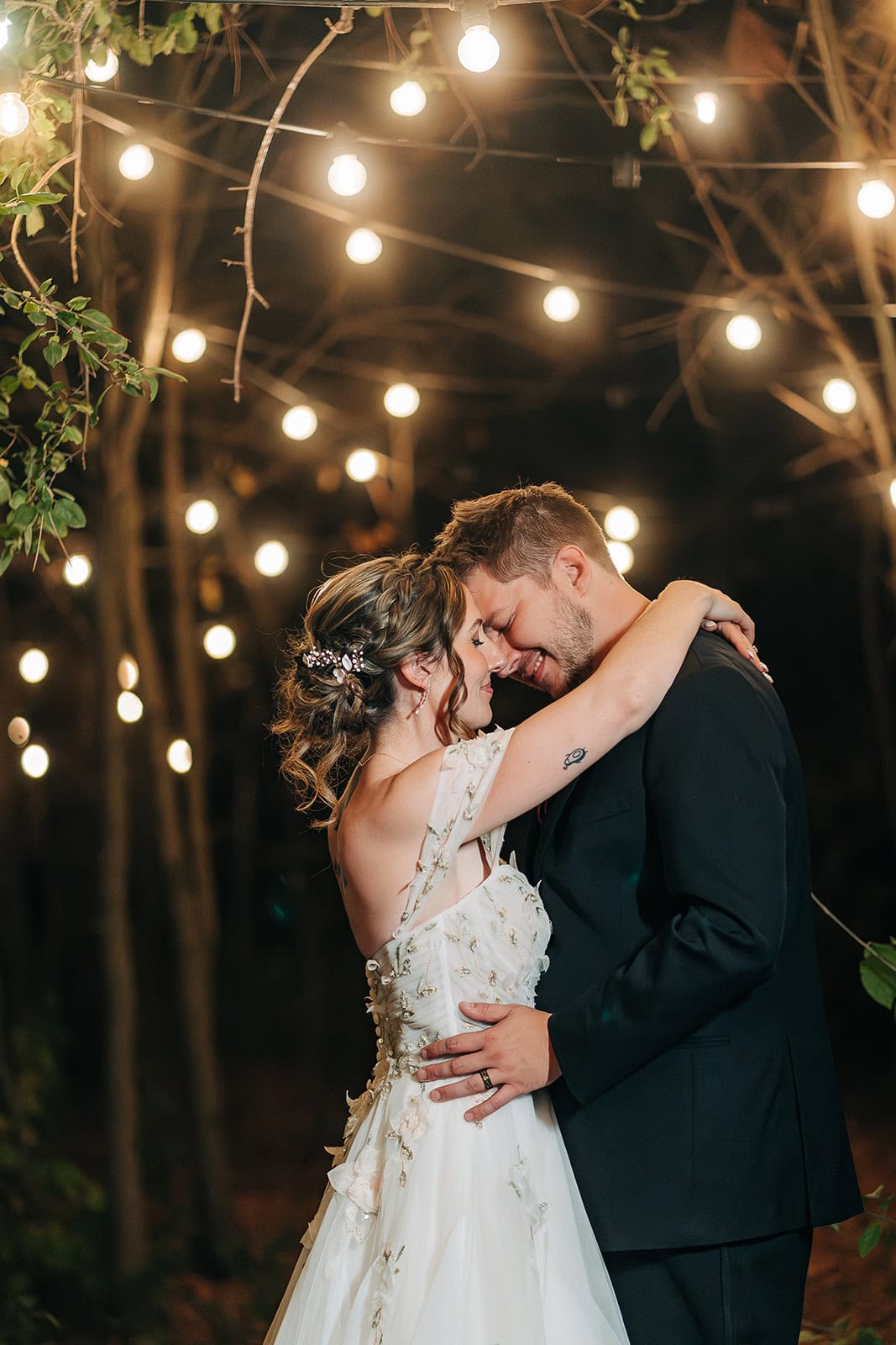 Bride and groom dancing at Ivory North wedding venue under string lights