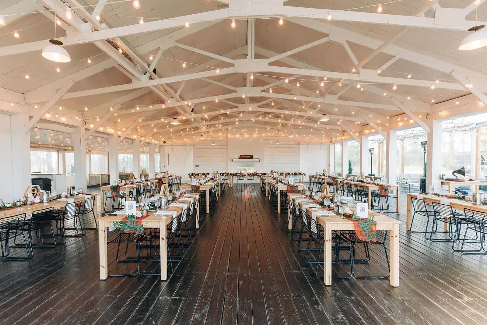 Ivory North wedding venue white barn interior with long farmhouse tables