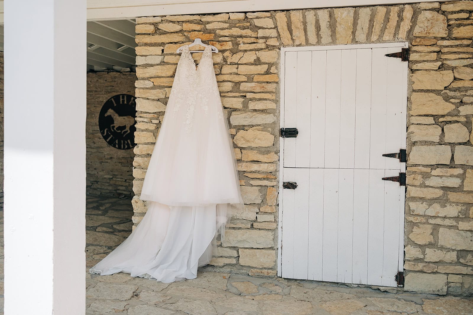 wedding dress hanging on limestone wall at Mayowood Stone Barn