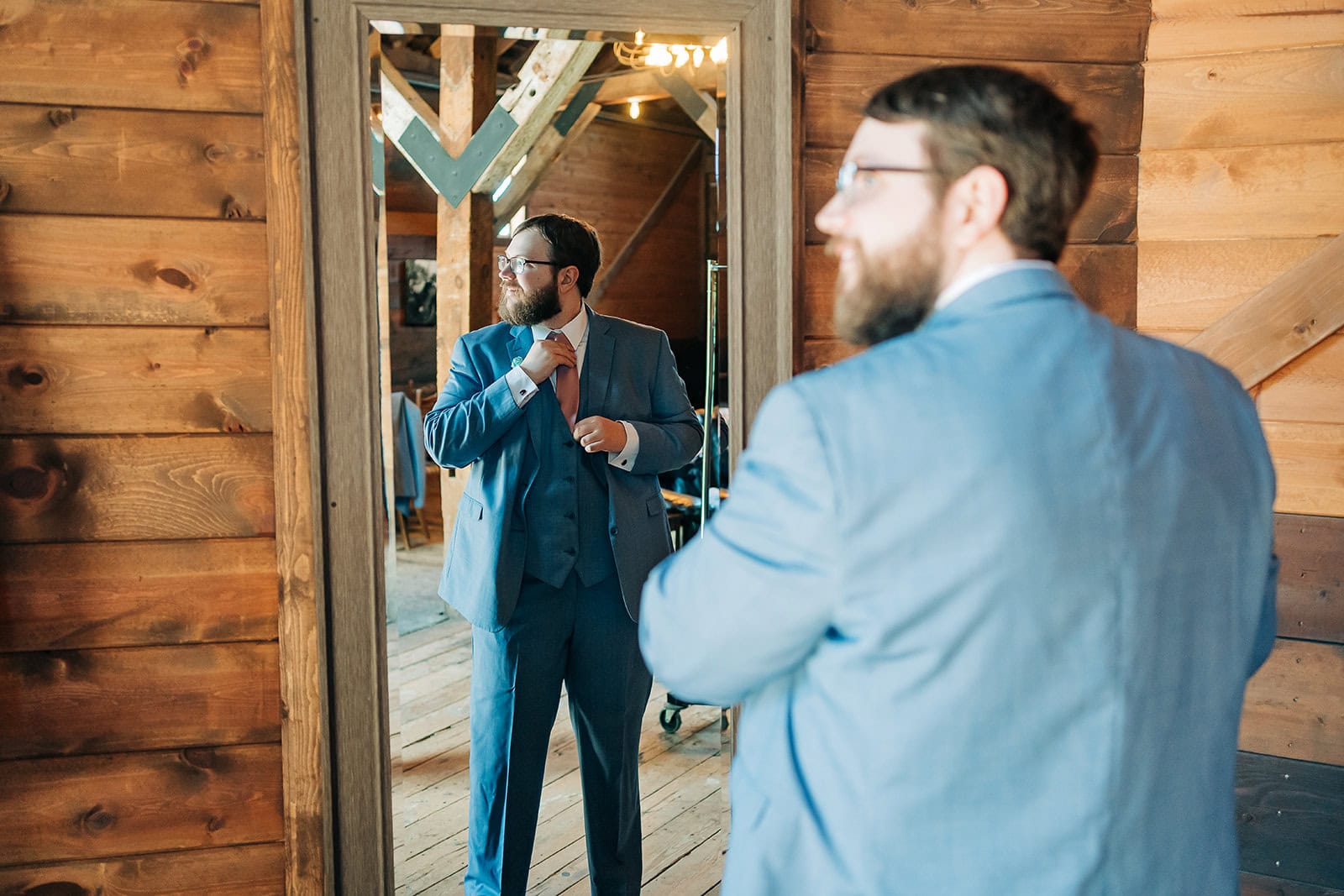 groom getting ready in mirror at Mayowood Stone Barn