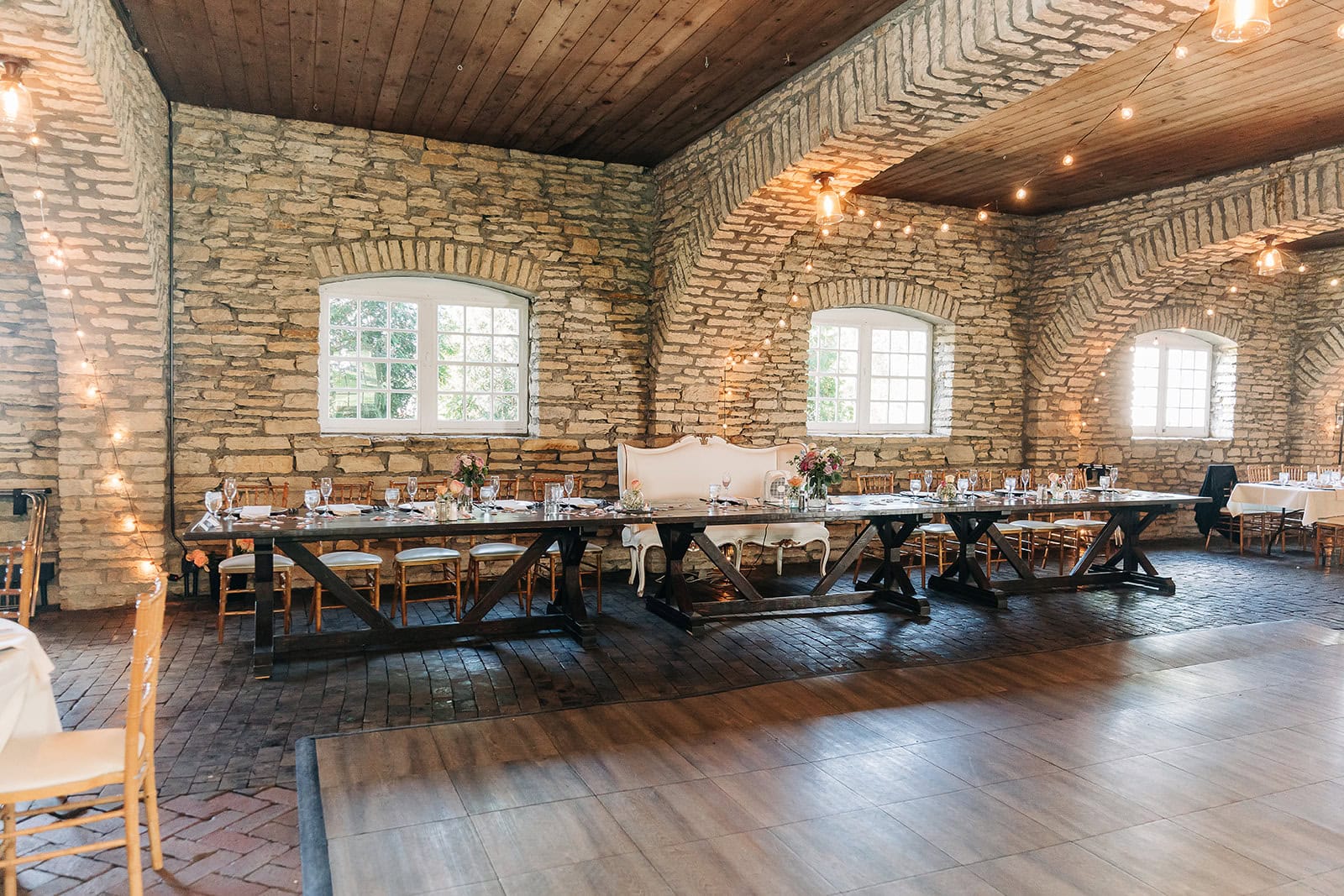 natural light pouring into stone barn reception space